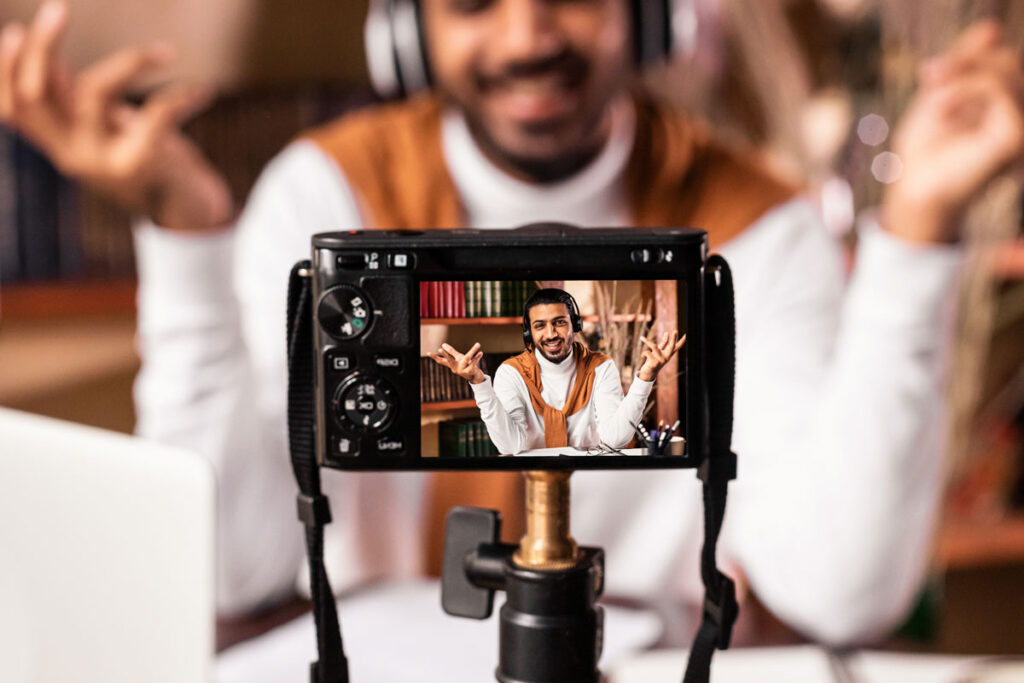 Online course creator filming video lesson while managing membership site and tech issues